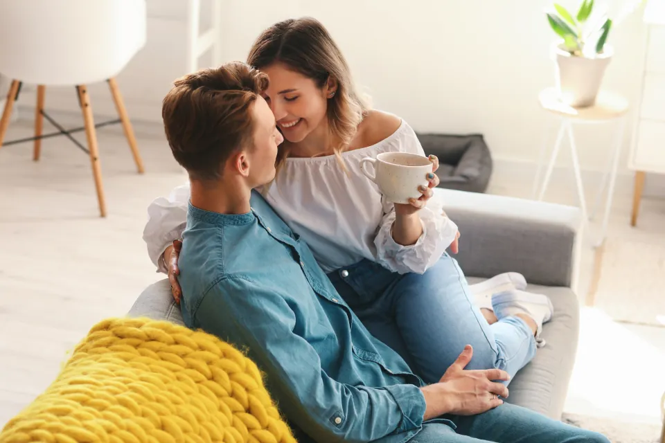Un couple rit ensemble sur un canapé