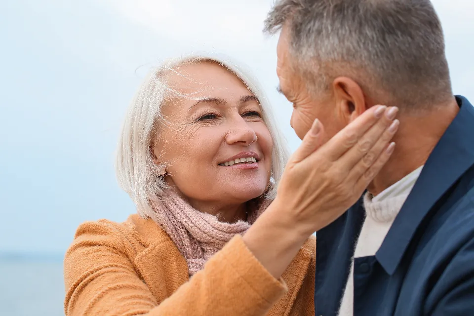 Une femme sourit, émue, pendant que son mari lui caresse la joue