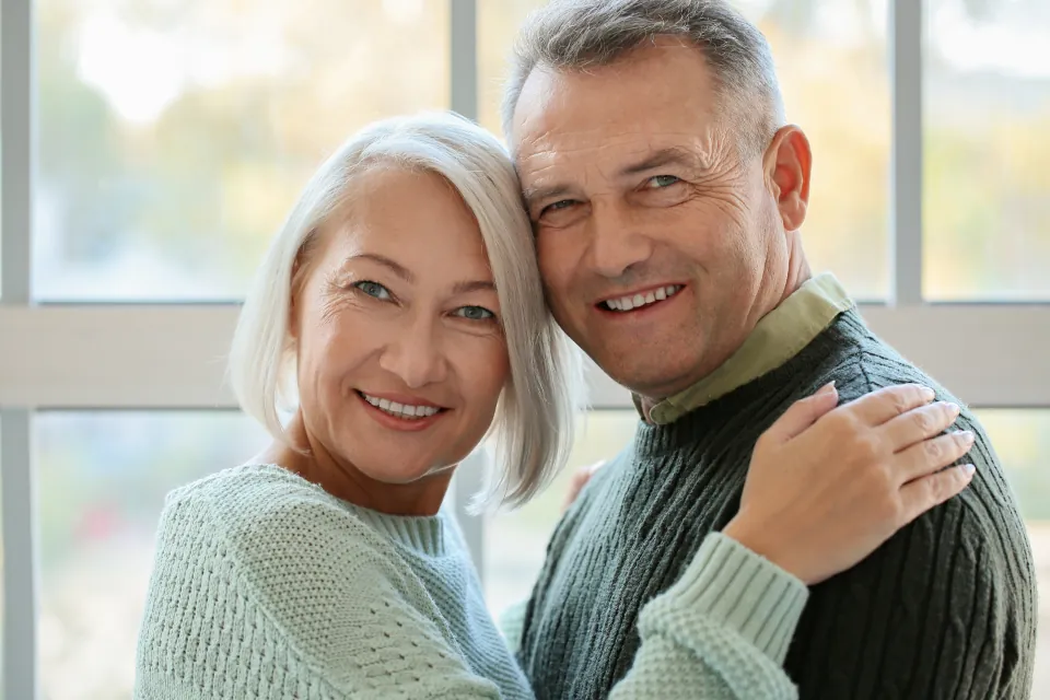 Un couple de seniors souriant, serré l'un contre l'autre